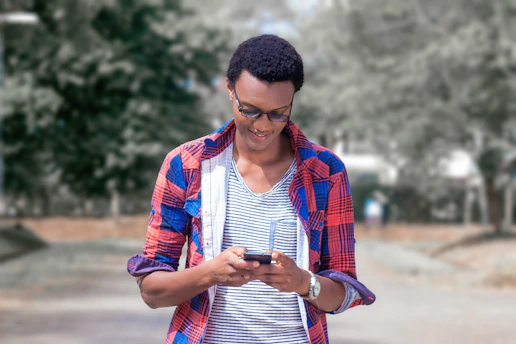 A friendly person checking job listings on a smartphone outdoors.