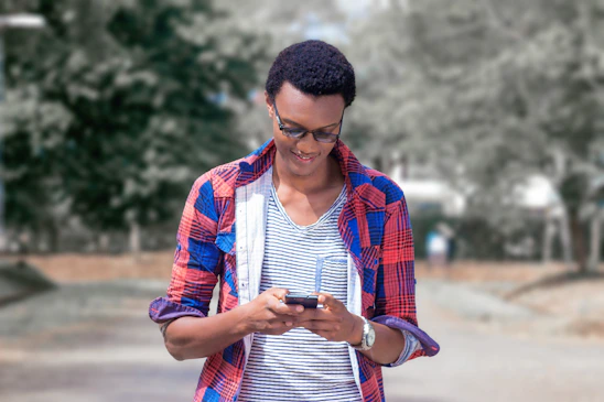 A friendly person using a smartphone outdoors, checking local cost and wait time data.