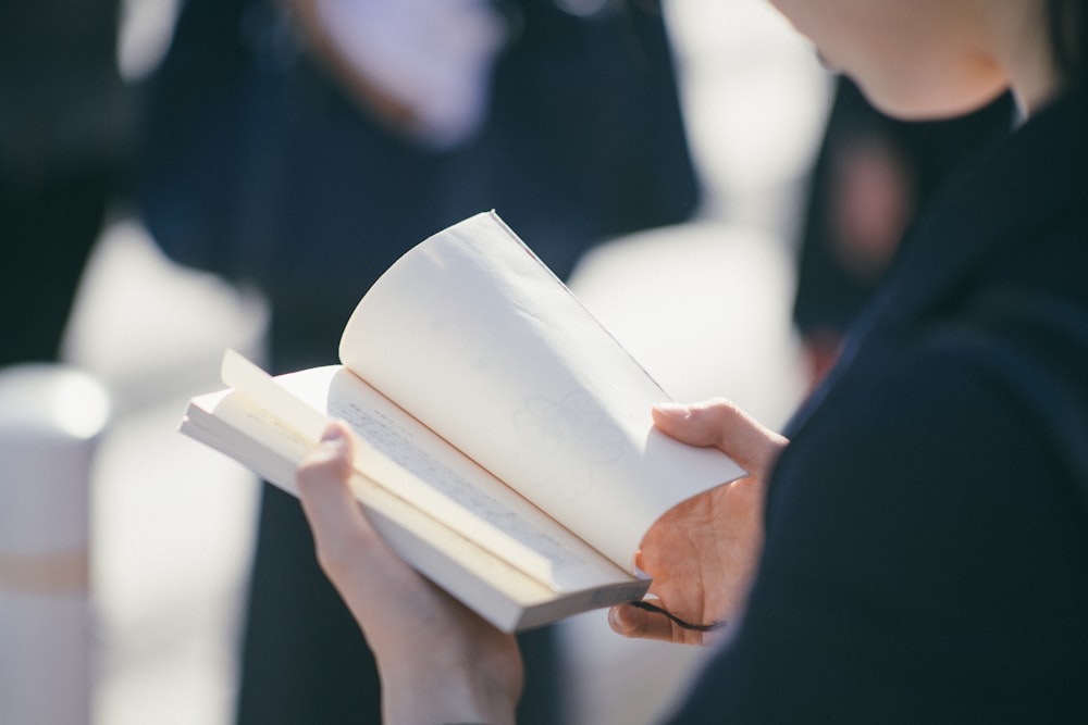 standing woman reading book at daytime