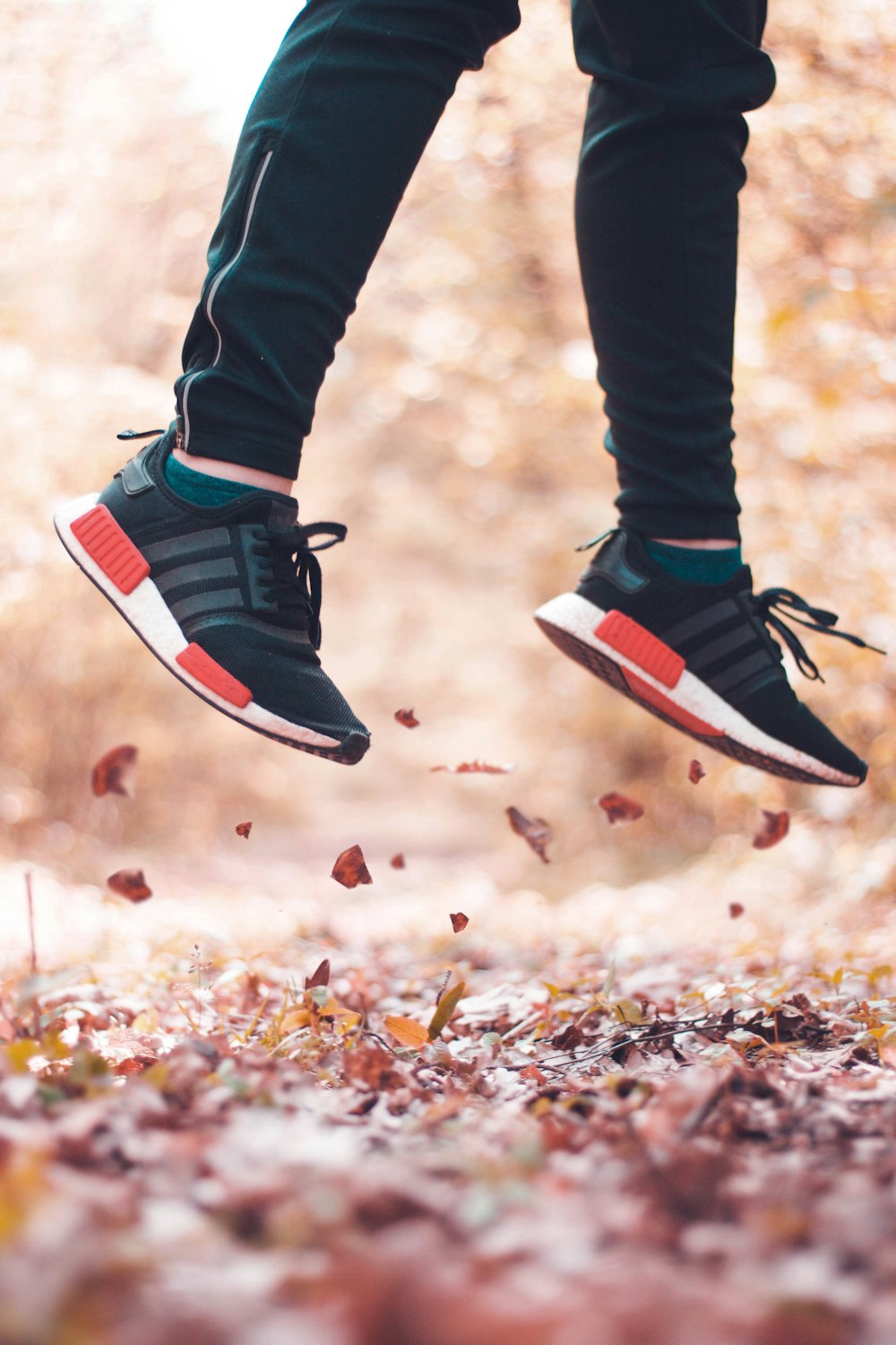 person jumping from leaves