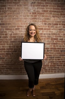 A smiling homeowner standing proudly beside their newly framed and drywalled living room.