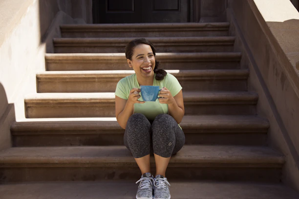 Photo of a happy customer holding a freshly printed mug and smiling outdoors.