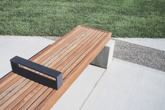 Modern stainless steel bench integrated in a hotel garden setting.