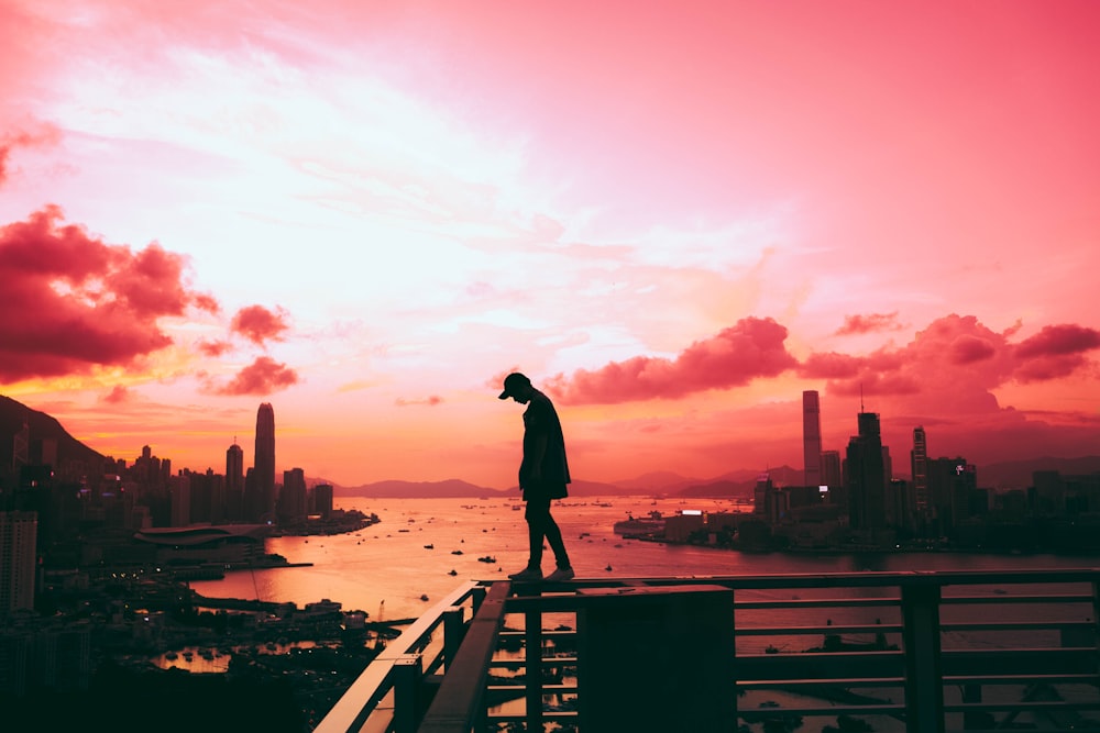 silhouette of person standing on railing