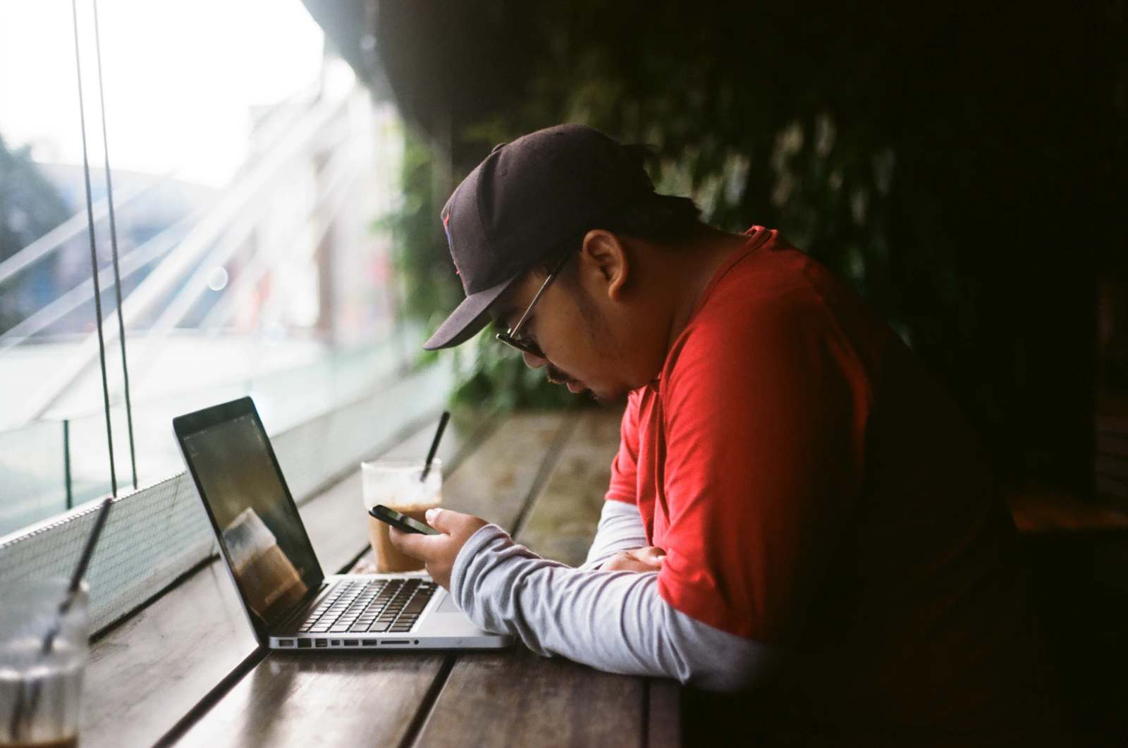 Person working at a compact cafe desk with a laptop and phone
