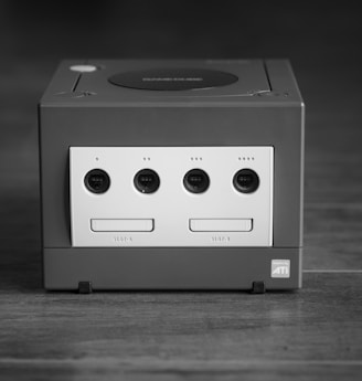 white and black Nintendo GameCube on gray surface