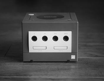 white and black Nintendo GameCube on gray surface