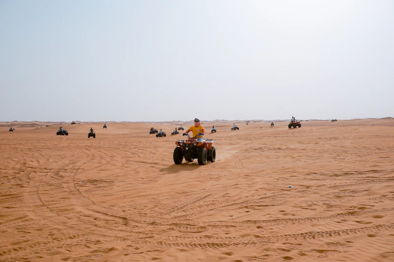 Quad bikes riding across flat sand in the Dubai desert