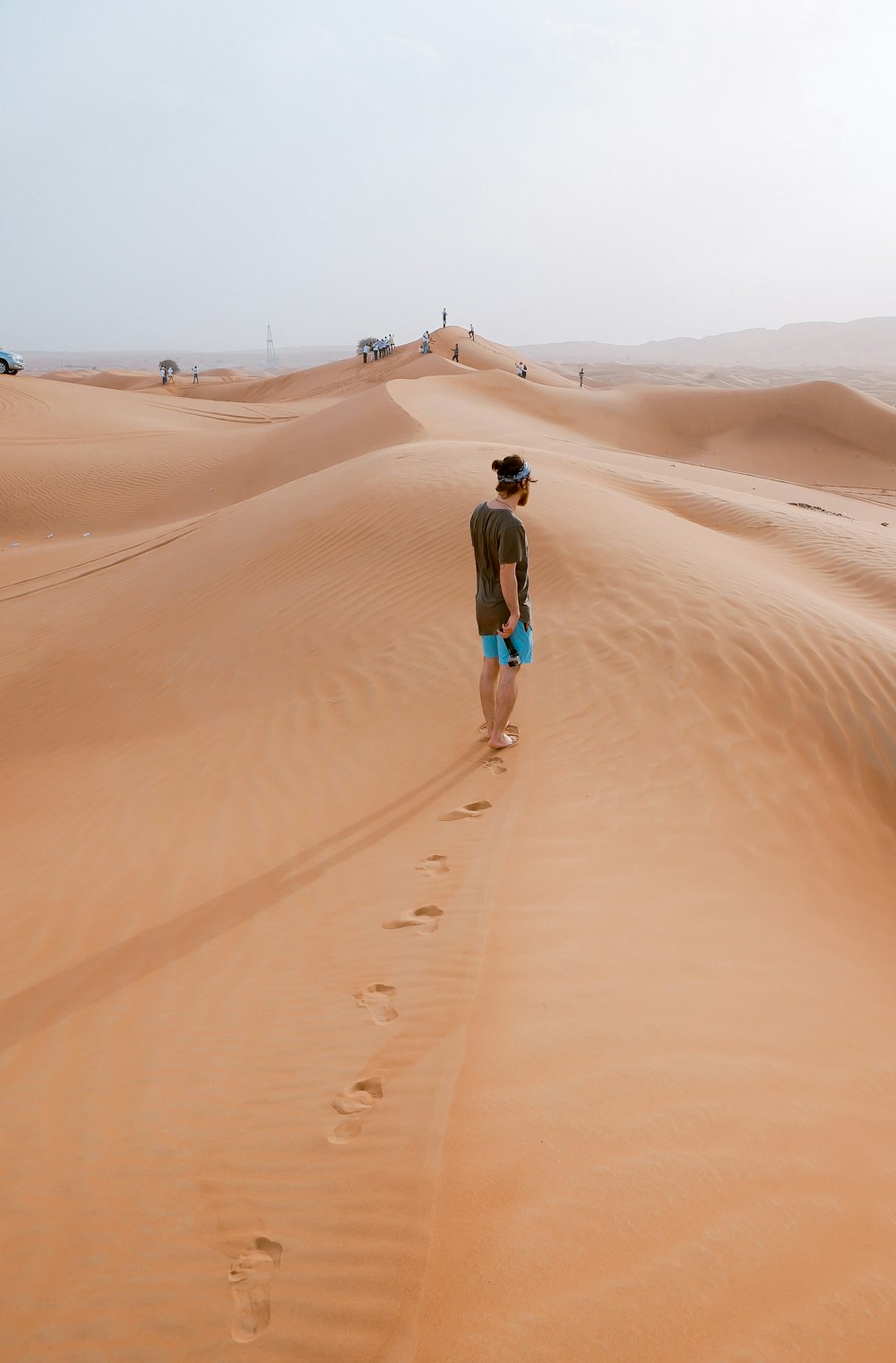 person standing on sand dune