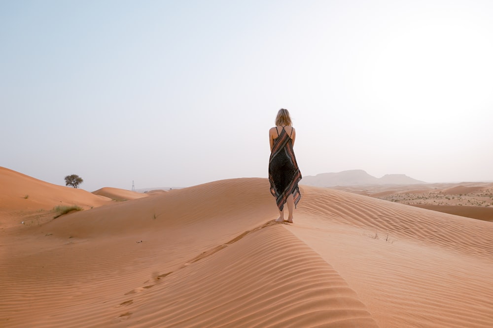 woman walking on desert during daytime