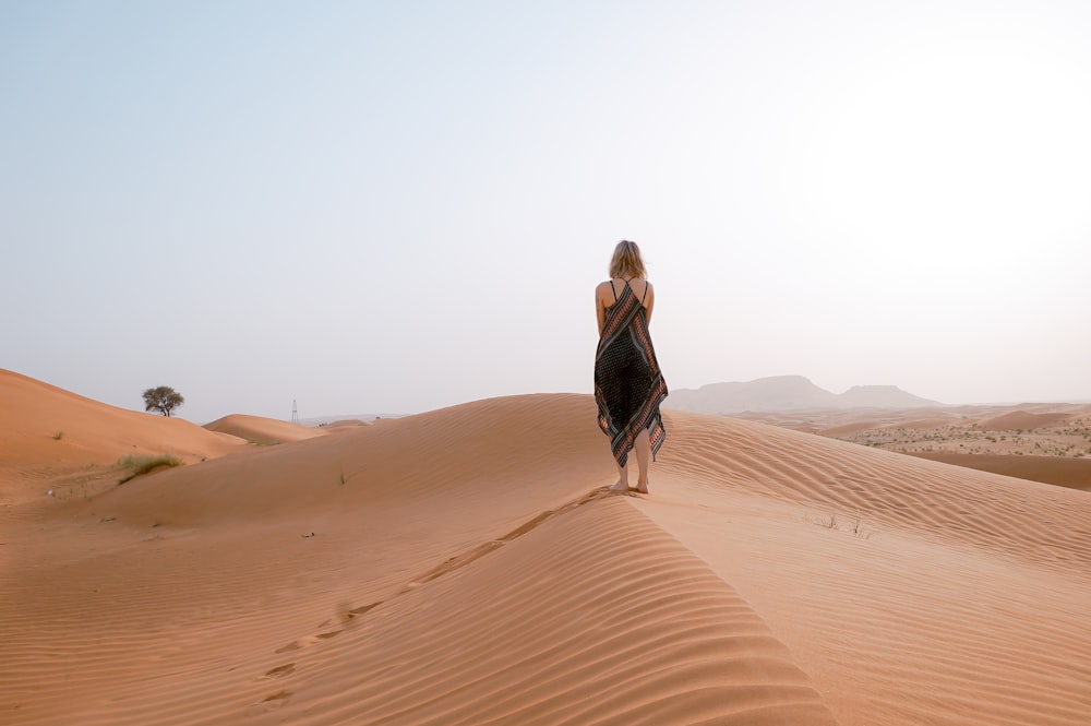 mulher que caminha no deserto durante o dia