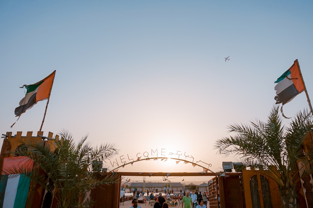 green palm trees besides Welcome arch