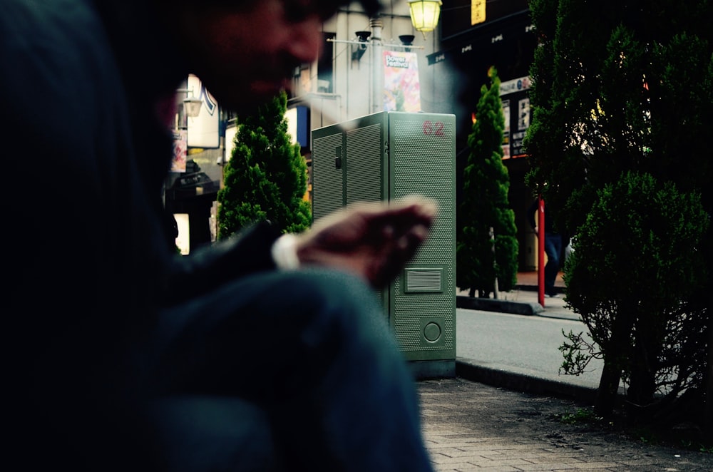 person taking cigarette while sitting