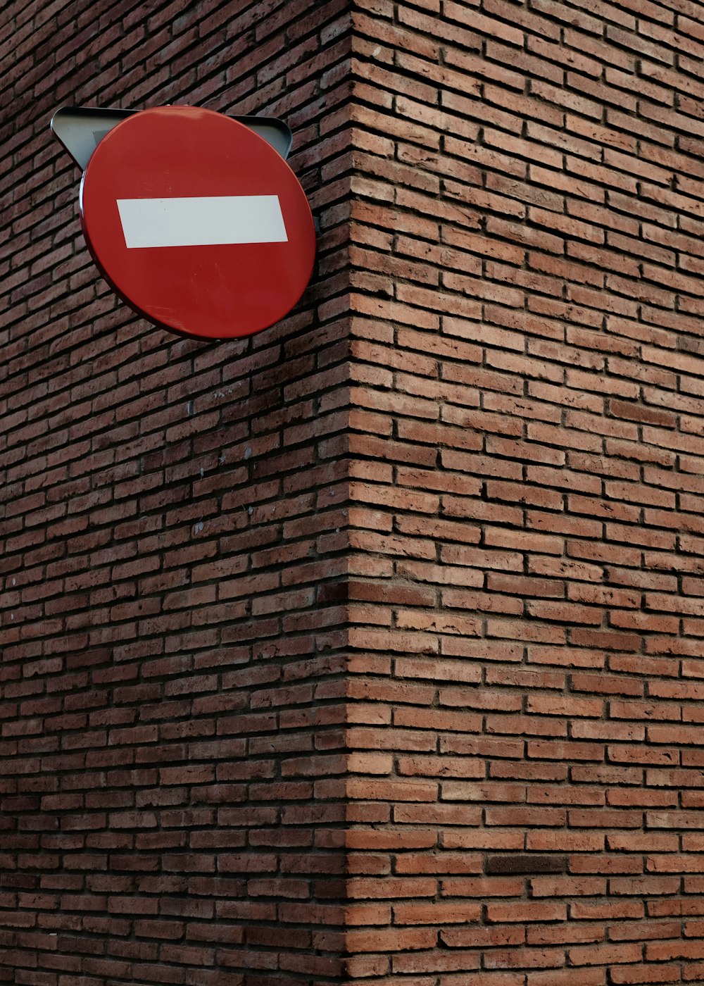 red and white signage on red brick wall at daytime