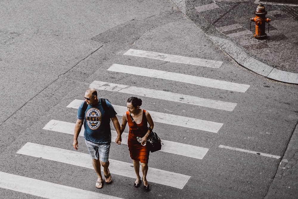 man and woman walking on pedestrian lane during daytime
