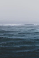 A panoramic view of the Atlantic sea with rolling fog and muted colors evoking calm and mystery.