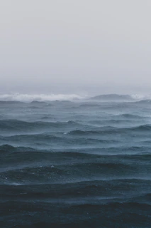 A panoramic view of the Atlantic sea with rolling fog and muted colors evoking calm and mystery.