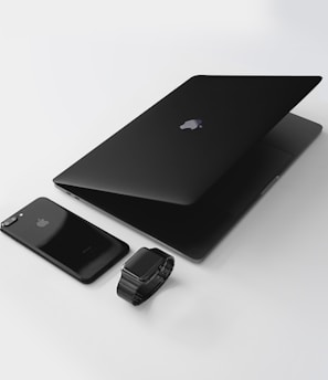 black Macbook near black iPhone 7 Plus and black Apple Watch