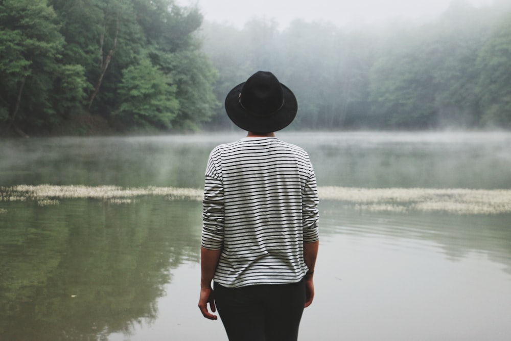 person standing near swamp lake during daytime