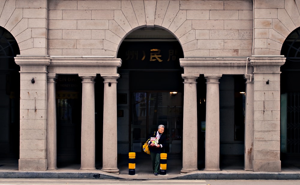 man standing in front of the gray building