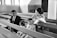 A family is seated on church pews. The scene includes a man in a suit, a woman in traditional attire, a young boy also dressed in a suit, and a girl in a dress. The woman and children seem engaged, with the man looking towards the girl.