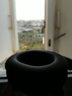 Close-up of a sleek black headphone accessory with urban graffiti in the background
