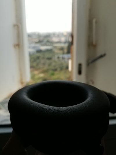 Close-up of a sleek black headphone accessory with urban graffiti in the background
