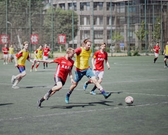 men playing soccer on field with fence