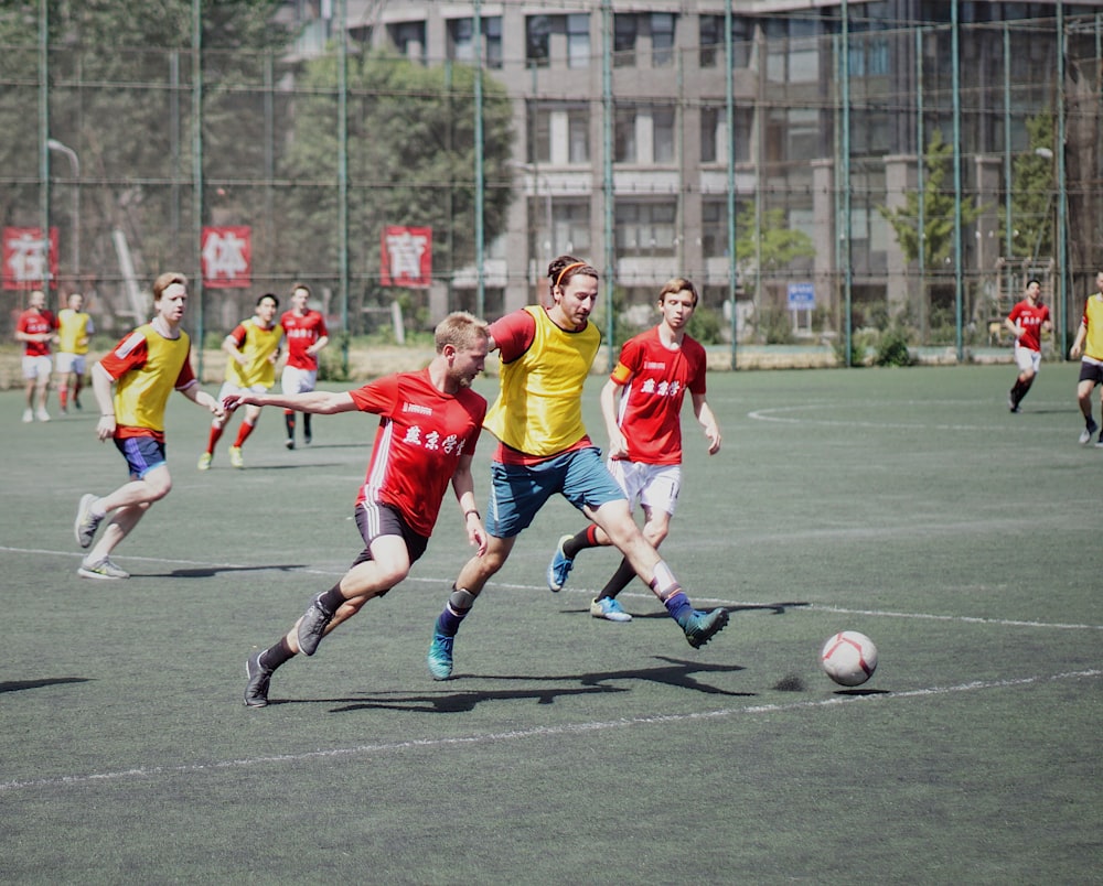 men playing soccer on field with fence