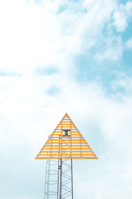 A bright yellow construction sign with the words 'buildlaunch' against a clear blue sky.