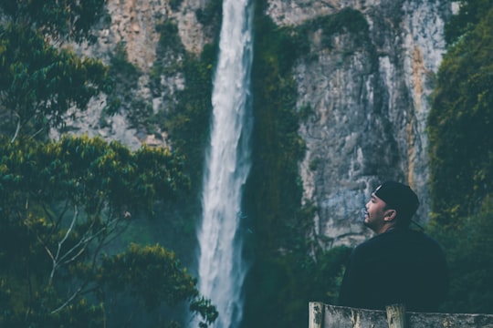 man standing near falls during daytime in Air Terjun Sipiso Piso Indonesia