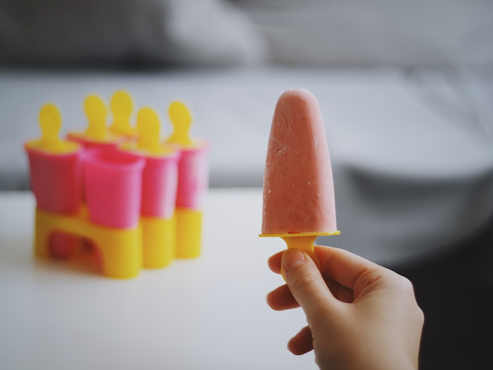 persona sosteniendo helado de paleta