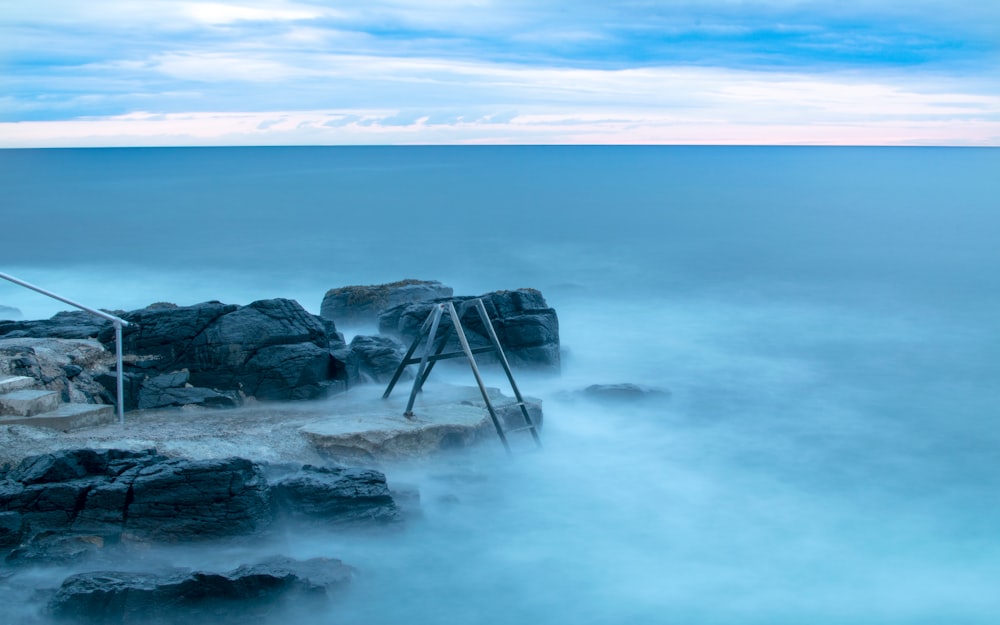 stone near body of water under cumulus clouds