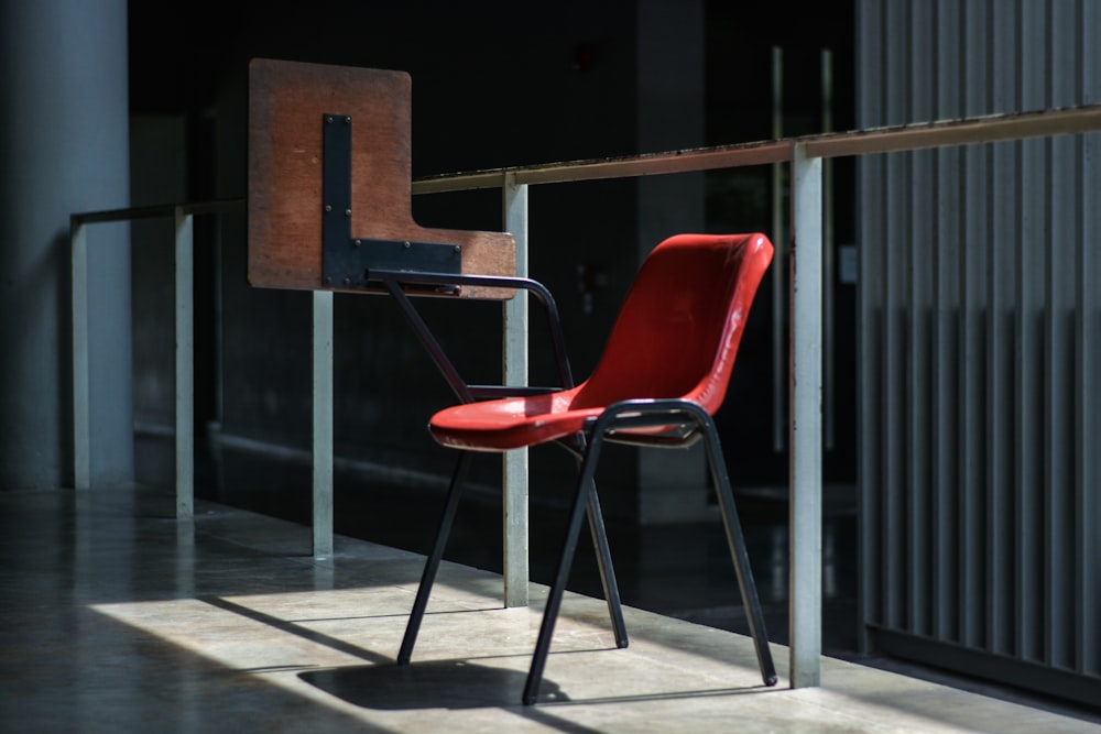 Chaise grise et rouge près du mur de verre