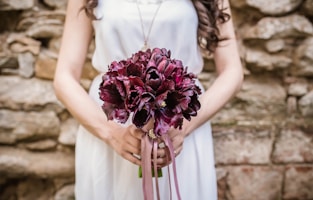 woman holding purple flower bouquet