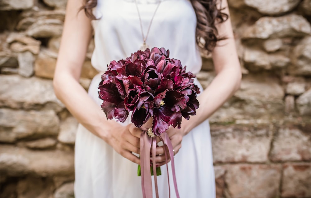 woman holding purple flower bouquet