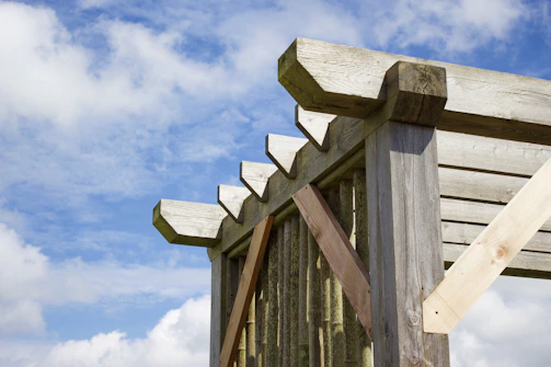 Outdoor metal pergola structure with elegant design, set against a clear sky.