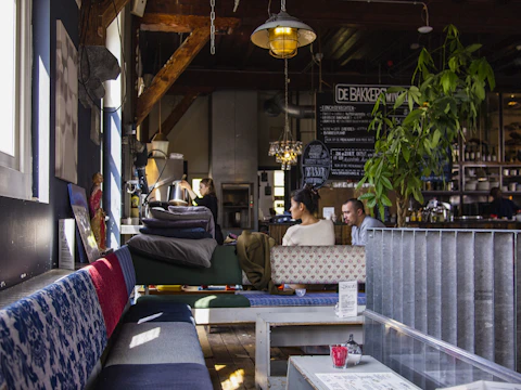 A cozy Scandinavian-style cafe with a social media strategist discussing content plans with the owner.