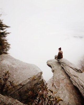 Meditating woman sitting on rock
