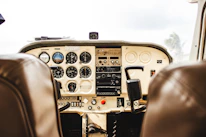 Close-up of a pilot reviewing flight plans inside a luxurious cockpit with polished instruments.