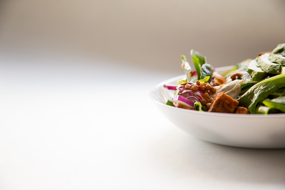 Fresh vegetable salad in a white bowl in the kitchen