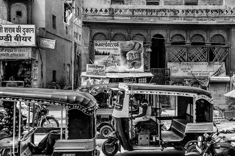 Classic Indian auto rickshaw and people in grayscale