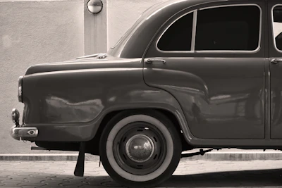 Sepia-toned photo of a vintage racing car with silver details on a dark blue backdrop