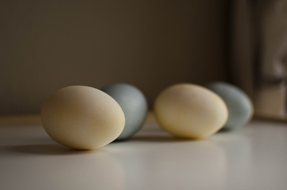 Tres huevos blancos sobre una mesa blanca