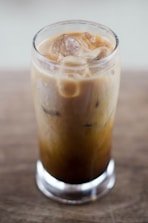 Tall glass of cold brew coffee with ice cubes and condensation on the glass.