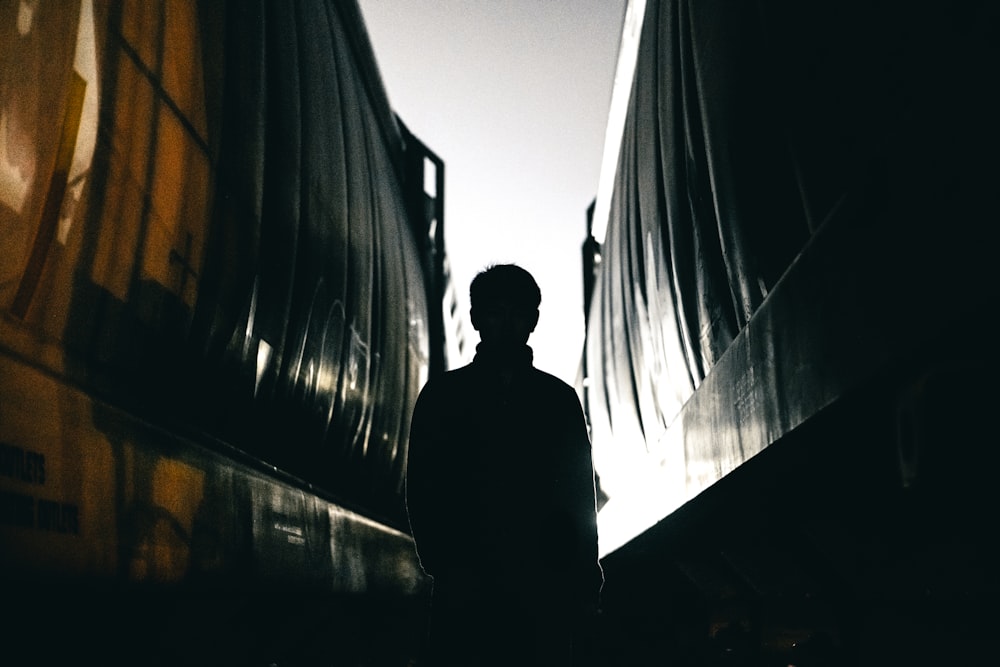 man standing between building silhouette