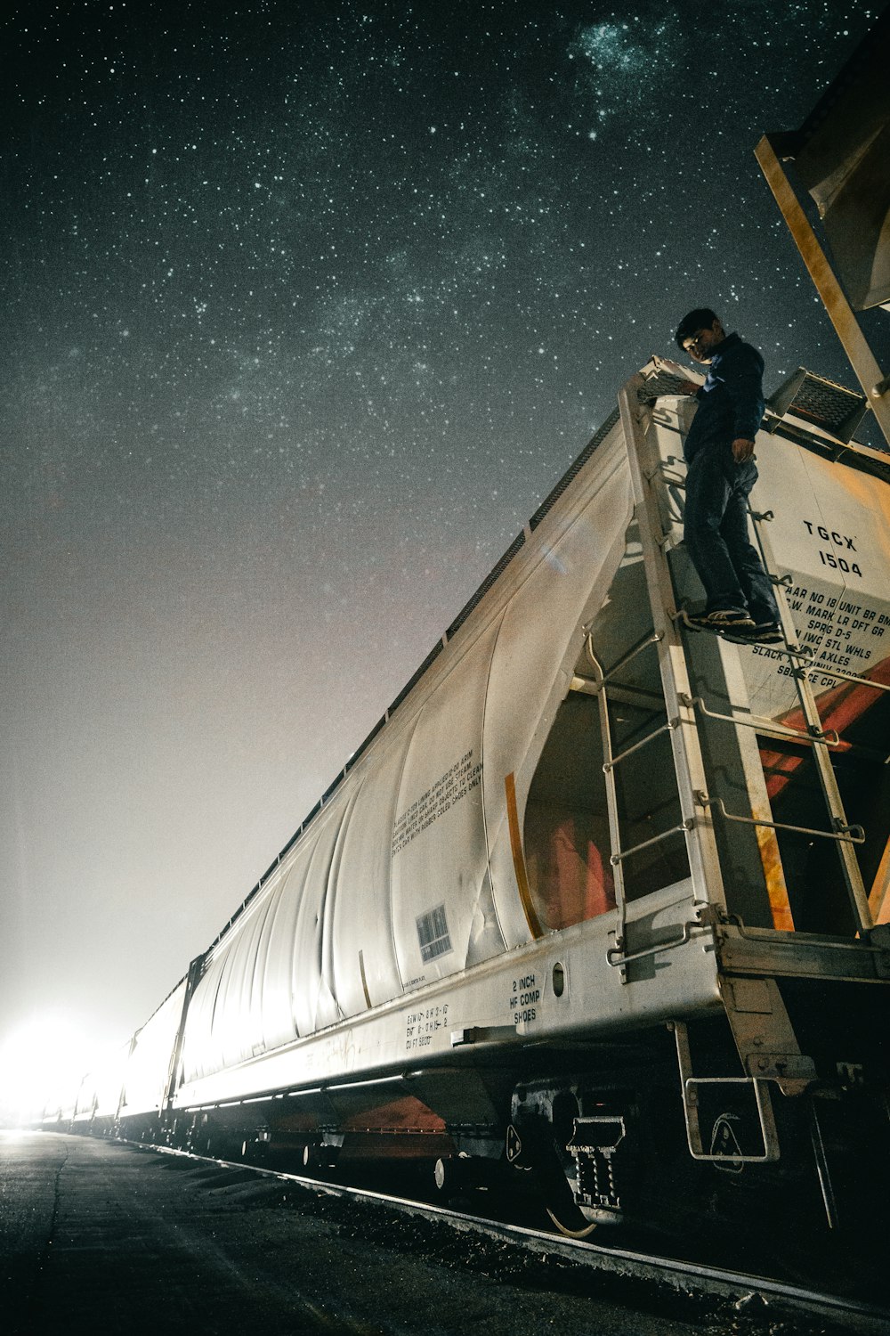 man riding white train on track at nighttime