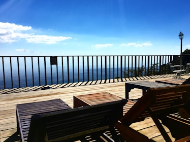 A spacious deck with comfortable seating and a view of a landscaped backyard.