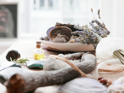 A collection of natural stones and essential oils arranged on a wooden tray.
