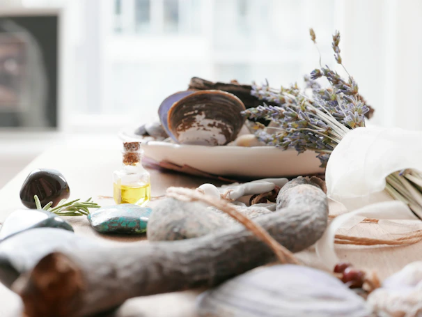 Natural elements like smooth stones and lavender candles arranged on a wooden shelf.
